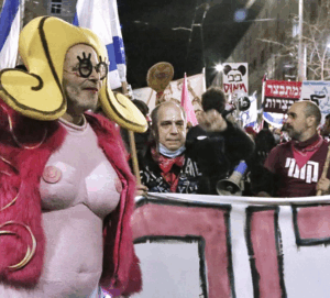 יגאל רמבם עם הציצים והכוס של שושקה אנגלמאייר בהפגנה